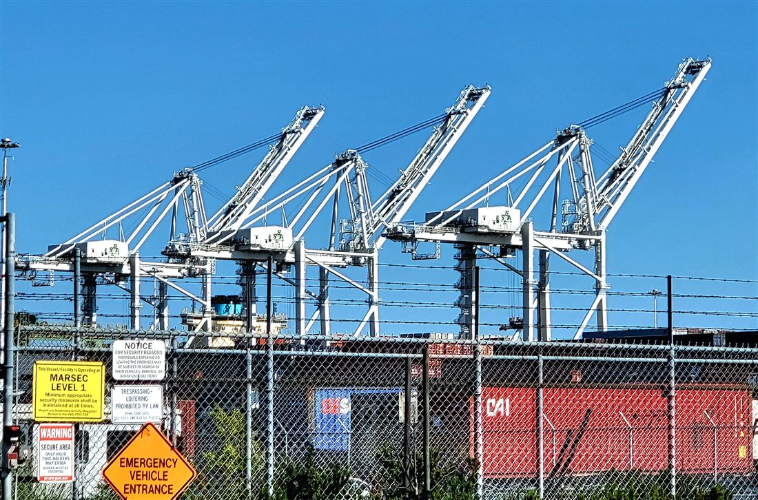 Grues portuaires chargeant des conteneurs dans un grand port de commerce.